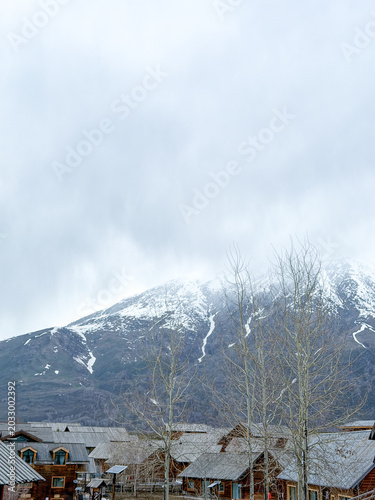 Majestic snow-capped Altai Mountains under a bright blue sky with clouds in Xinjiang, China.