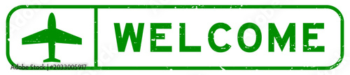 Grunge green welcome word with plane icon square rubber seal stamp on white background