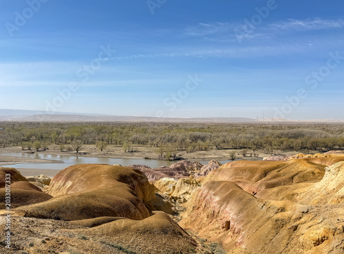 Stunning landscape of Wucaitan (Five Colored Hills) and the Irtysh River in Burqin, Xinjiang, China.
