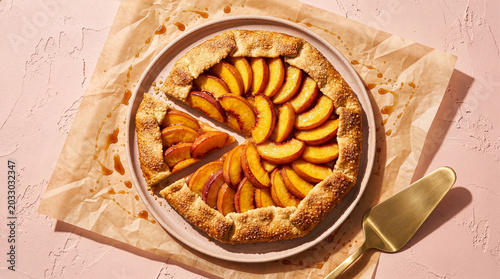 Fényképezés Delicious homemade peach galette with golden crust and caramel sauce served on a
