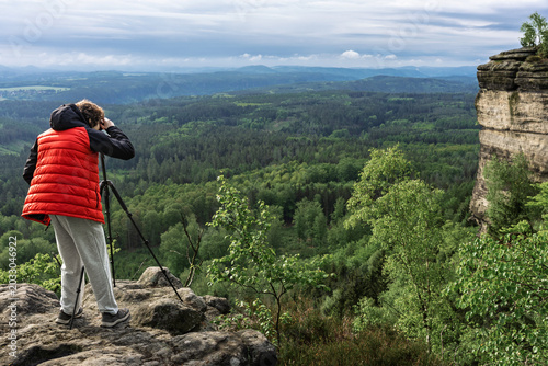 Schilderij op canvas Teenager photographing landscape from Grosser Zschirnstein, Saxon Switzerland, Germany