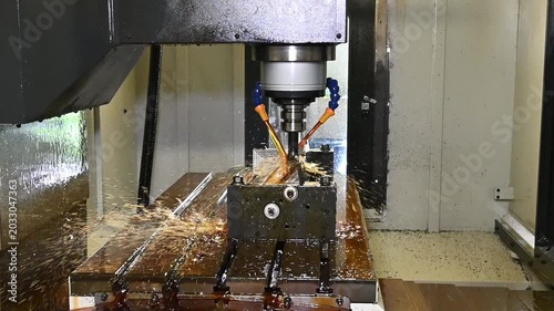 Slow motion video of a CNC milling machine rough cutting mold parts using an oil coolant method.