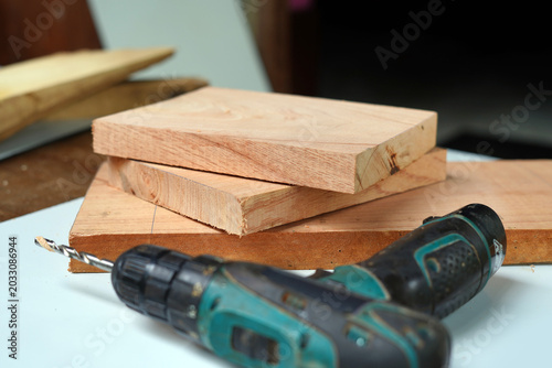 Drill and wood pieces on the table. image