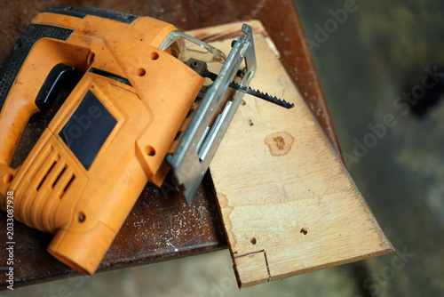 Cutting after wood piece on the table with electric saw. image