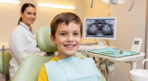 Smiling child sitting in dental chair with dentist in background