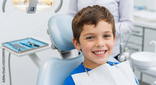 Smiling boy sitting in dental chair at dentist office