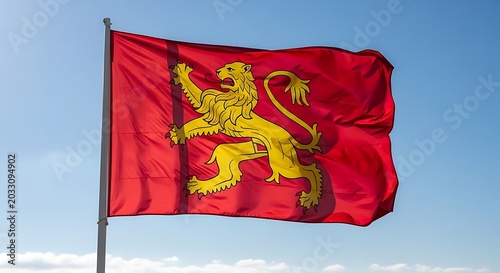 Flanders region flag waving in the wind against a clear blue sky