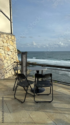 Quadro em tela Outdoor terrace with table and chairs overlooking the ocean waves