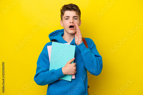 Schilderij op canvas Teenager Russian student man isolated on yellow background with surprise and sho