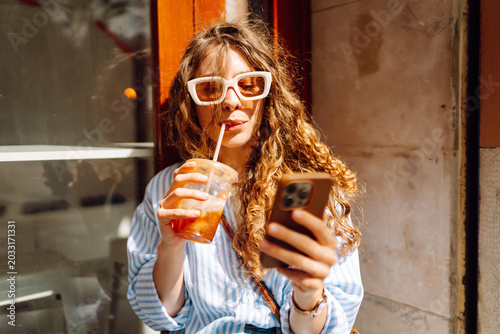Slika na platnu Young woman sits in front of a cafe