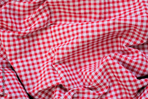 Red and white check table cloth background. Top view. Copy space. Summer outdoor food or picnic theme.