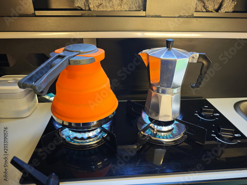 Making coffee and boiling water on a gas stove inside a modern camper van.