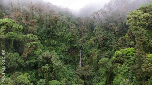 Drone flying forward towards a hidden waterfall in the cloud forest of Coronado, Costa Rica