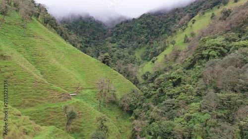 Drone flying forward into a lush green mountain valley in Coronado, Costa Rica