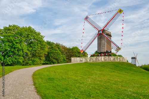 Historic windmills lining the old ramparts of Bruges during golden hour