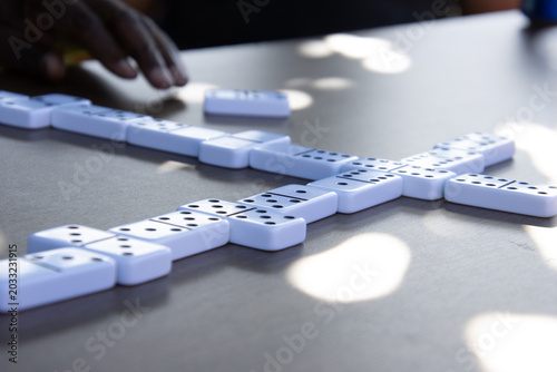 Hand placing domino tile during tabletop game