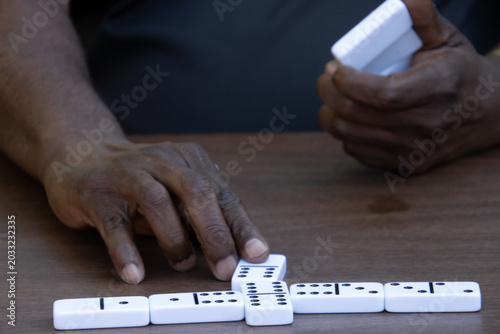 Playing dominoes at table with hands in frame