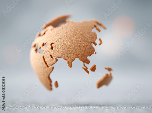 A minimalist globe with metallic rose gold continents floats against a soft grey background, focusing on Asia and Australia.