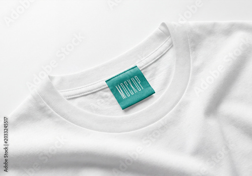 White cotton t-shirt collar mockup with a turquoise fabric clothing label tag on a clean white background