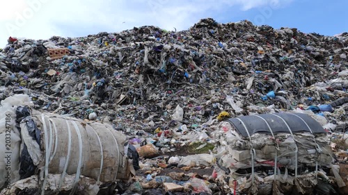 Landfill area filled with large piles of waste and debris shows the impact of pollution on the environment in daylight