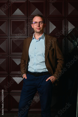 a man in a three-piece suit against a dark wall