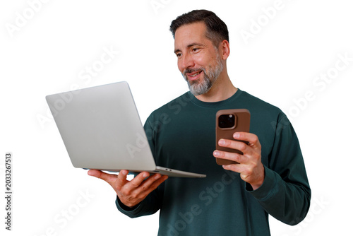 Foto Bearded man smiling, multitasking with laptop and smartphone, communicating and