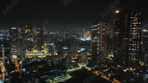 A stunning aerial night view of Mumbai’s high-rise buildings, glowing with city lights and showcasing the vibrant energy of India’s financial capital. The illuminated skyscrapers and skyline of Mumbai