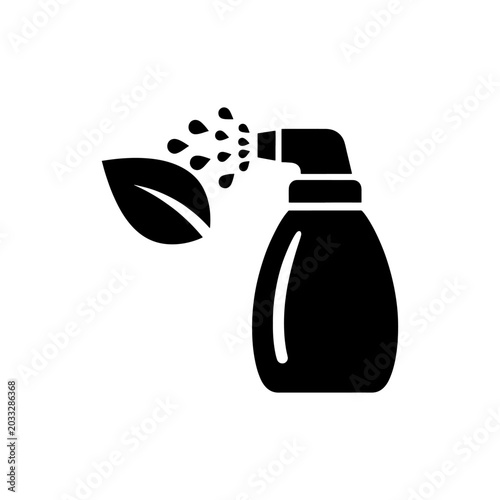Fotografía A black spray bottle emits droplets near a leaf represented in a stark silhouett