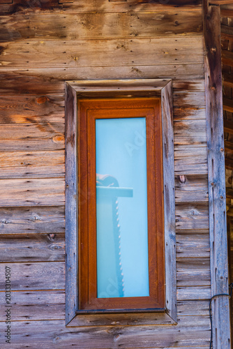 Window in wooden wall of the ancient residential building