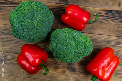 Green broccoli cabbage and bell pepper on wooden background. Healthy eating