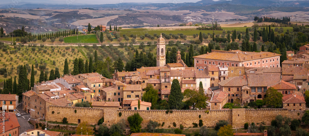 Obraz premium Italy San Quirico d'Orcia aerial panoramic view of Tuscany rolling hills valley background red roof tiles historic borgo townscape, classical Val d'Orcia landscape countryside