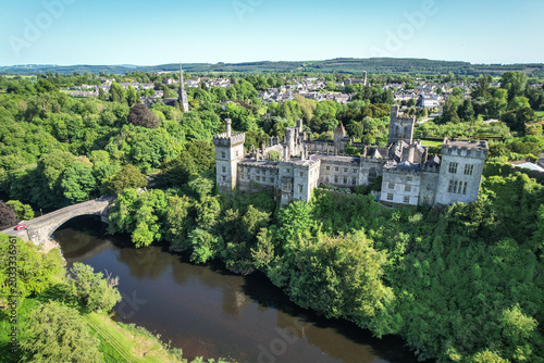 Drone aerial view of Lismore Castle on a clear blue sky day in County Waterford, Ireland