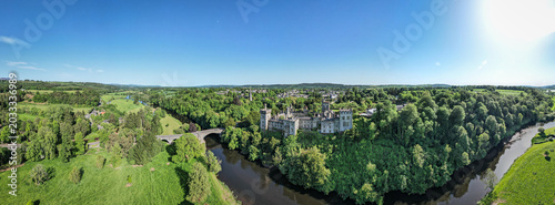 Drone aerial view of Lismore Castle on a clear blue sky day in County Waterford, Ireland