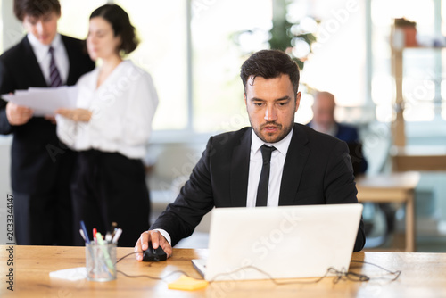 Photos Business adult man concentrating on tasks while working at computer at office ta
