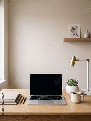 Laptop with blank screen on wooden desk with coffee and plant