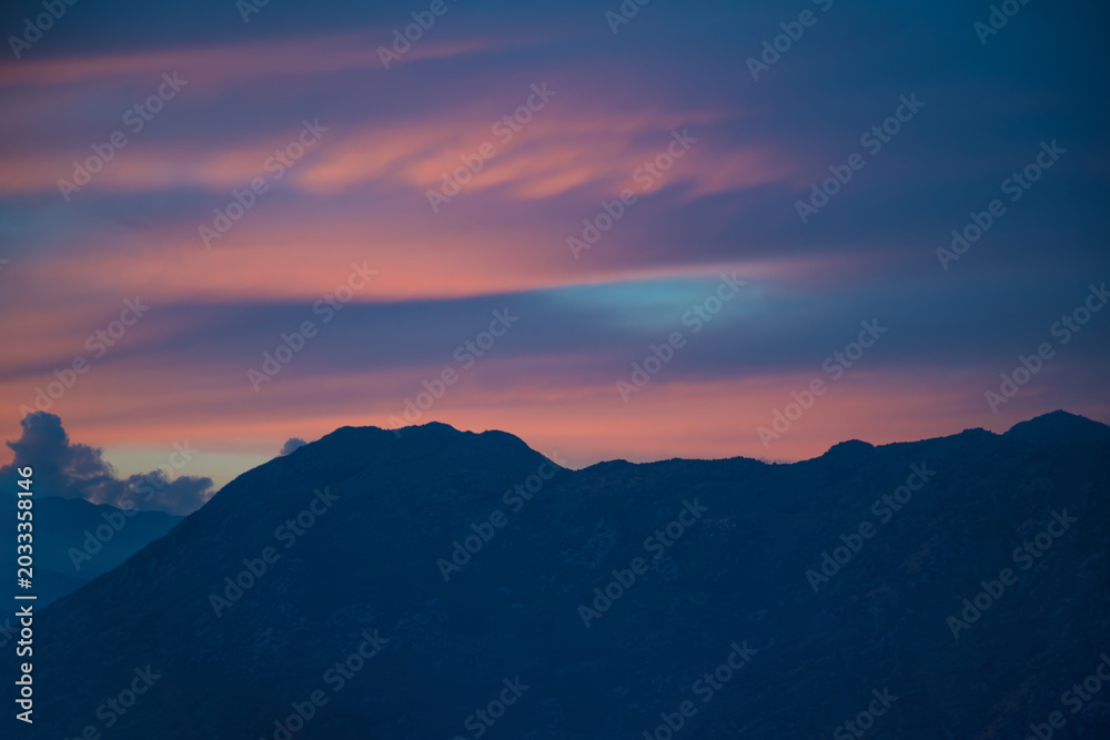 Obraz premium Tranquil Twilight Clouds Over Mountain Silhouettes. Dramatic Sunset Sky Above the Evening Landscape.