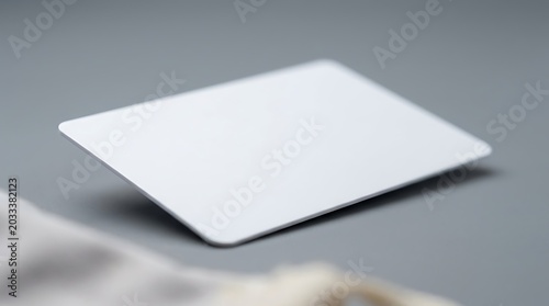 Blank white plastic identification card mockup on smooth grey surface for corporate branding and membership display