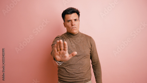 Bild auf Leinwand Serious man making a stop gesture, showing refusal and denial