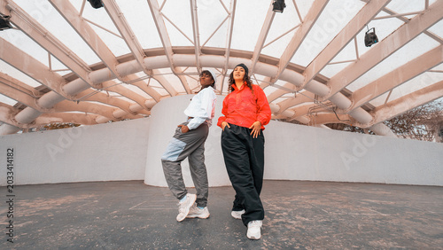 Fotografia Two diverse hip hop dancers standing confidently in urban athletic wear