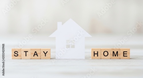 White House Symbol and Wooden Blocks Spelling Stay Home on a Light Surface