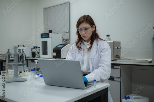 Female Scientist Researching in Laboratory with Test Tubes and Equipment