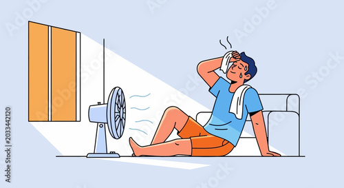 Man sweating and feeling hot, sitting in front of a fan during a heatwave