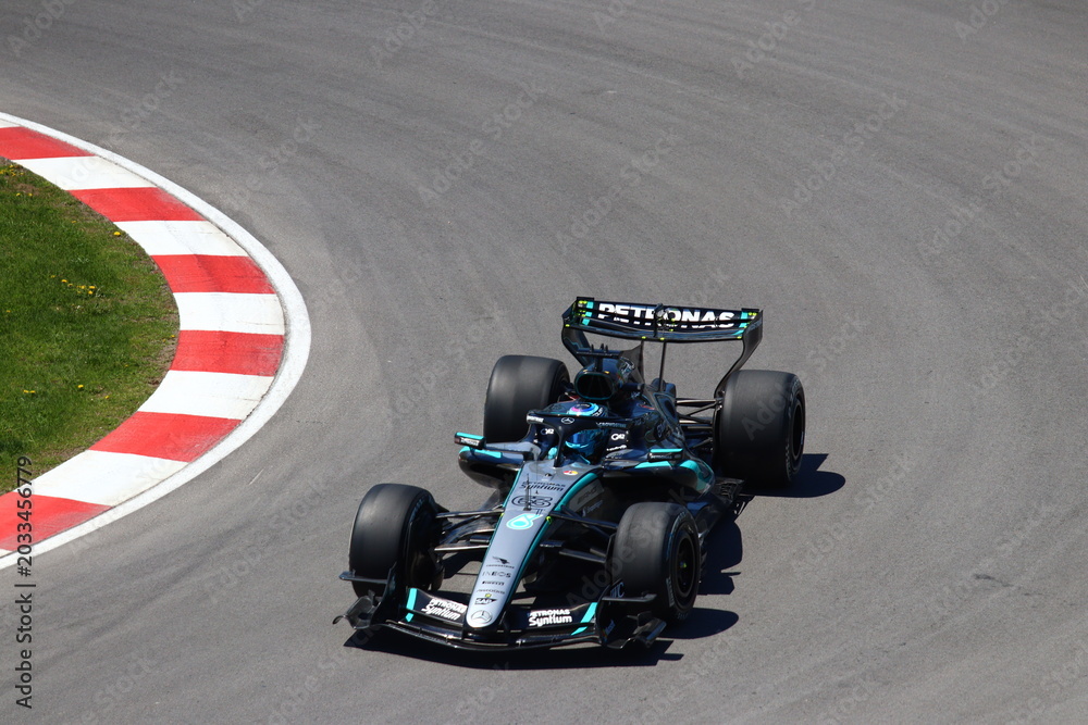 Obraz premium May 24, 2026, Montreal, Canada, Mercedes F1 car racing through Circuit Gilles Villeneuve corner. g.