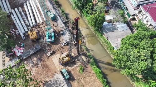 dredging mud on the riverbank in densely populated areas in the city center using heavy equipment such as excavators and dump trucks
