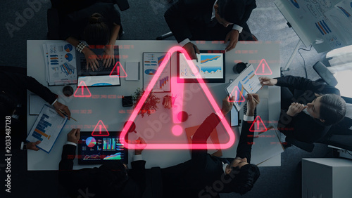 Foto A group of business professionals engage in an important meeting, analyzing data on charts while warning symbols emphasize the need for immediate action and critical decisions