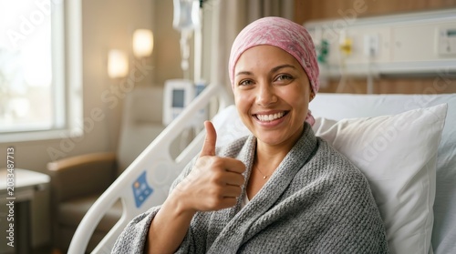 Cheerful cancer survivor giving a thumbs up in a hospital bed.