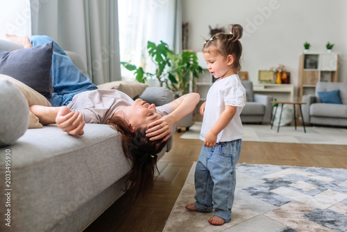 Tired mother lacks energy, lying down and exhausted