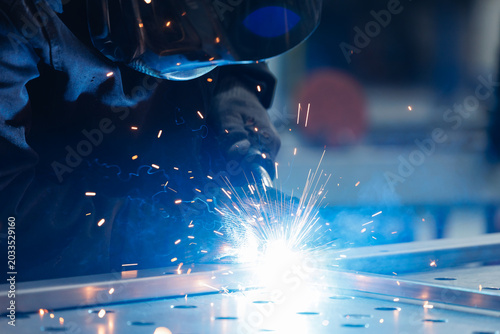 Konstfotografi Work of industry welder creating bright arc and sparks on metal table in factory