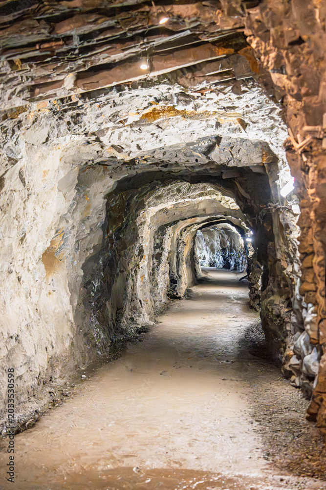 Obraz premium Interior view of the Wieliczka Salt Mine in Poland showing long underground tunnels and carved passageways. The site is a popular tourist attraction celebrated for its history.