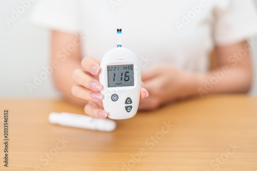 Bild auf Leinwand Hand checking Diabetes or Blood glucose self testing by digital blood glucose meter with lancet pen